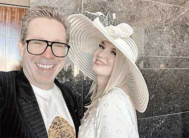 Mark Malatesta wearing black glasses with Ingrid Elfver wearing a white hat