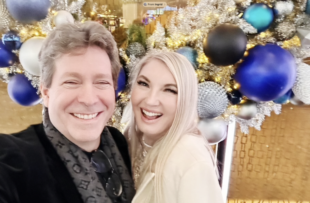 Mark Malatesta wearing dark suit and grey scarf with Ingrid Elfver dressed in all white