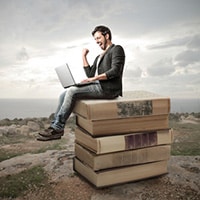 Man with computer and books learning how to write your book